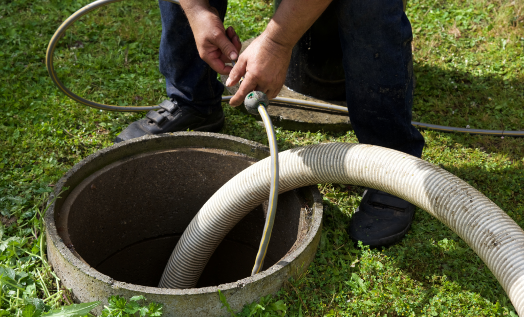 Technician guiding a hose into a round drainage basin