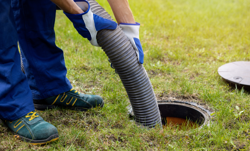 Technician guiding a vacuum hose into a yard catch basin