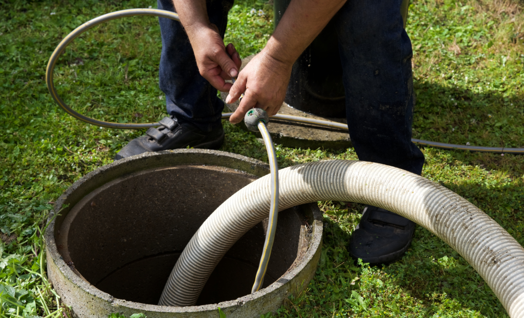 Hose inserted into a round catch basin in a lawn